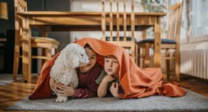 dogs and children hiding under a blanket together