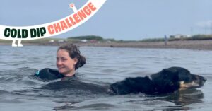 Woman swimming wild water with her black and tan dog