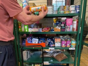 image of man filling shelves with pet food